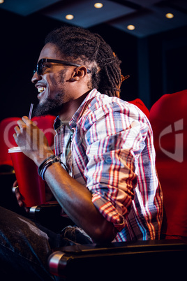 Young man watching a 3d film and drinking soda