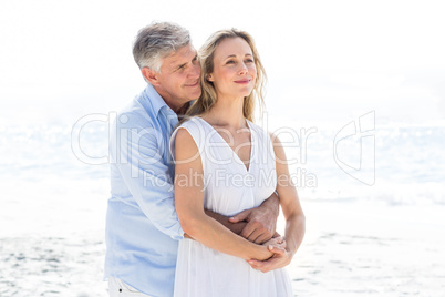 Happy couple standing by the sea and hugging each other