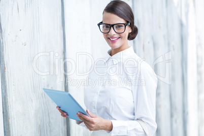 Pretty woman using her tablet pc looking at camera