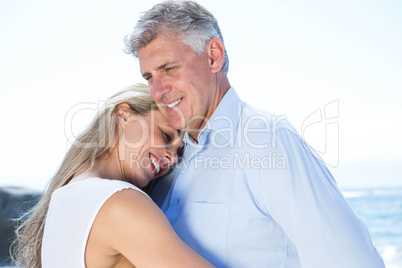 Happy couple standing by the sea and hugging each other