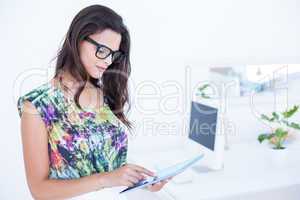 Smiling beautiful brunette standing in front of her computer