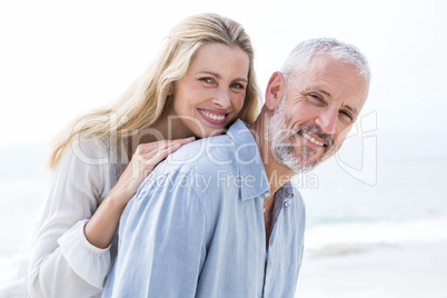 Happy couple hugging each other and smiling at camera