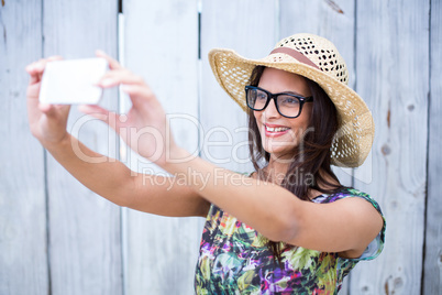 Smiling beautiful brunette taking selfie