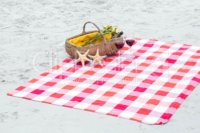 Picnic basket with glasses of red wine and starfishes on a blank