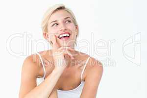 Pretty blonde woman smiling with finger on cheek