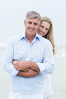 Happy couple hugging each other and looking at camera