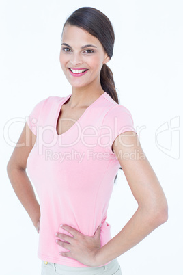 Happy brunette woman looking at camera with hands on hips