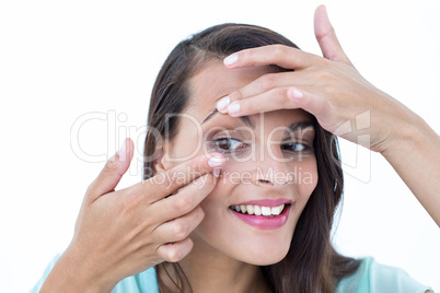 Beautiful woman applying contact lens