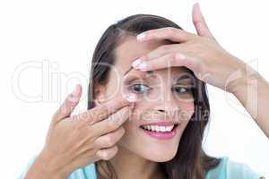 Beautiful woman applying contact lens