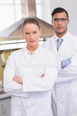 Serious scientists looking at camera with arms crossed