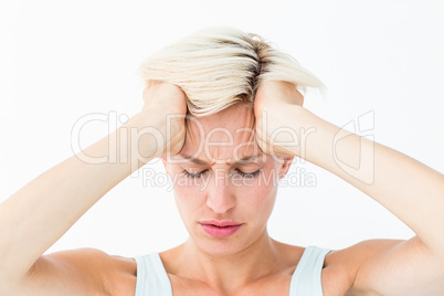 Blonde woman suffering from headache holding her head