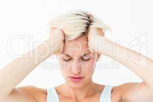 Blonde woman suffering from headache holding her head