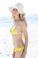 Smiling fit blonde in bikini looking at camera