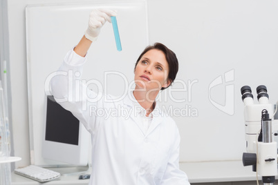 Scientist looking attentively at test tube