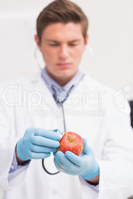 Scientist listening apple with stethoscope