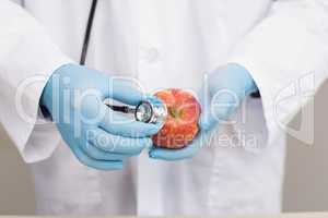 Scientist listening apple with stethoscope