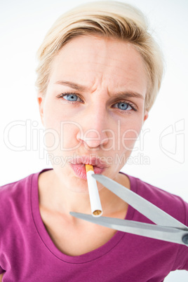 Beautiful blonde cutting a cigarette