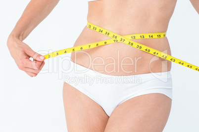 Attractive woman measuring her belly