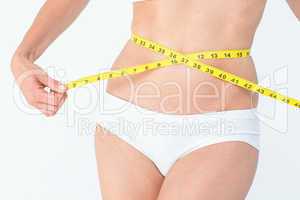 Attractive woman measuring her belly