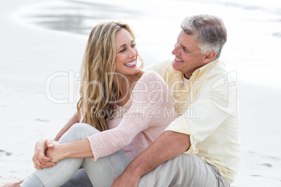 Happy couple sitting on the sand