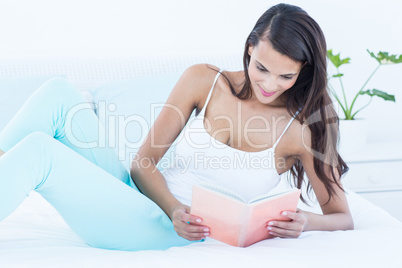 Beautiful woman reading on her bed