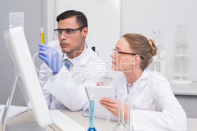 Scientists examining yellow precipitate in tube