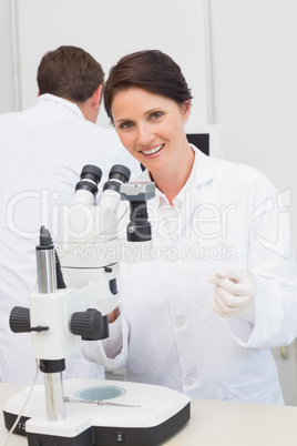 Scientists working with microscope and computer