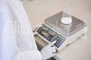 Scientist weighing beaker with white powder inside