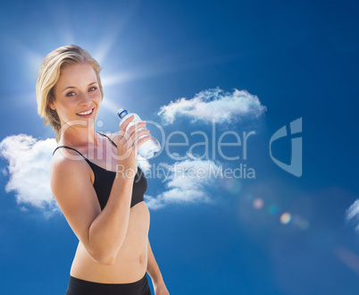 Composite image of fit blonde drinking water