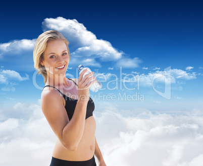 Composite image of fit blonde drinking water