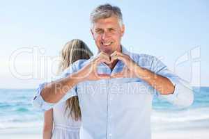 Smiling man doing heart shape with his hands