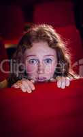 Young woman watching a scary film