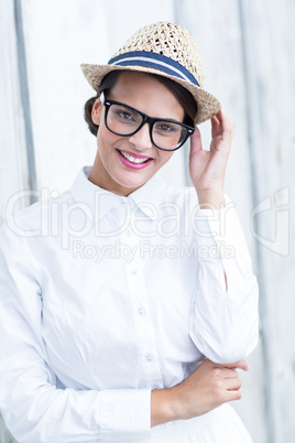 Pretty brunette looking at camera with hand on hat