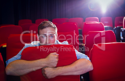 Young man watching a scary film