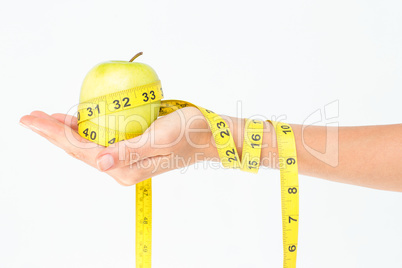 Woman holding an apple with tape measure