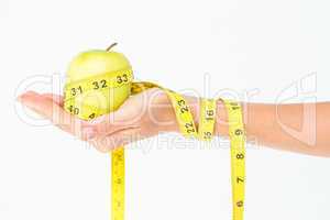 Woman holding an apple with tape measure