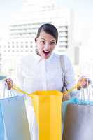 Surprised woman looking in shopping bag