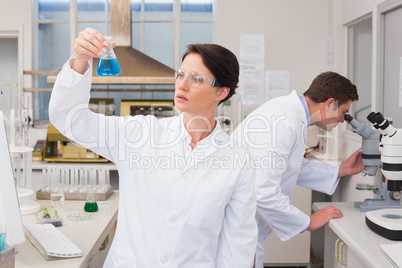 Scientists working with microscope and beaker