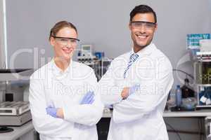 Smiling scientists looking at camera arms crossed