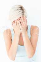Sad blonde woman crying with head on hands