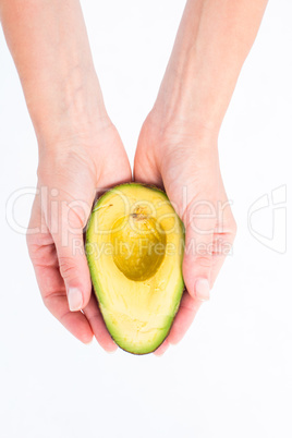 Woman presenting half of an avocado