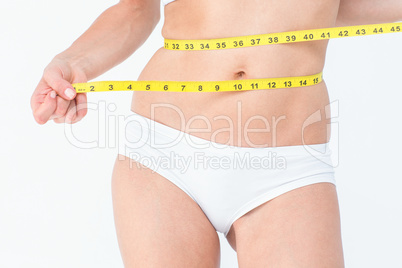 Attractive woman measuring her belly