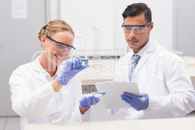 Scientists looking at petri dish and taking notes