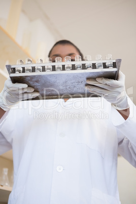 Scientist holding tray with test tubes