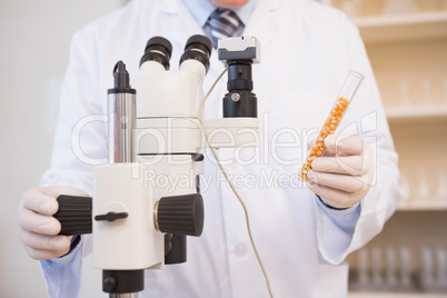 Food scientist holding test tube with seeds