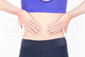 woman in sportswear touching her back