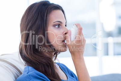 Beautiful brunette using inhaler