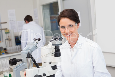 Scientists working with microscope and computer