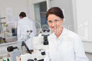 Scientists working with microscope and computer