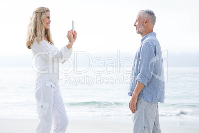 Happy couple taking pictures with mobile phone
